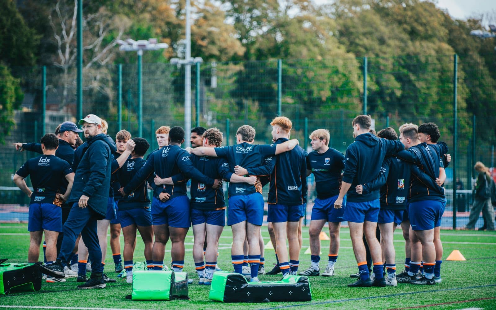 A rugby team huddled together on the field